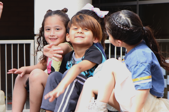 three children sitting outside